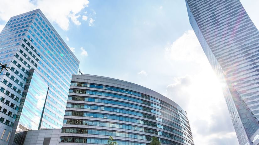 A view of office buildings from afar with the sun shining on one building