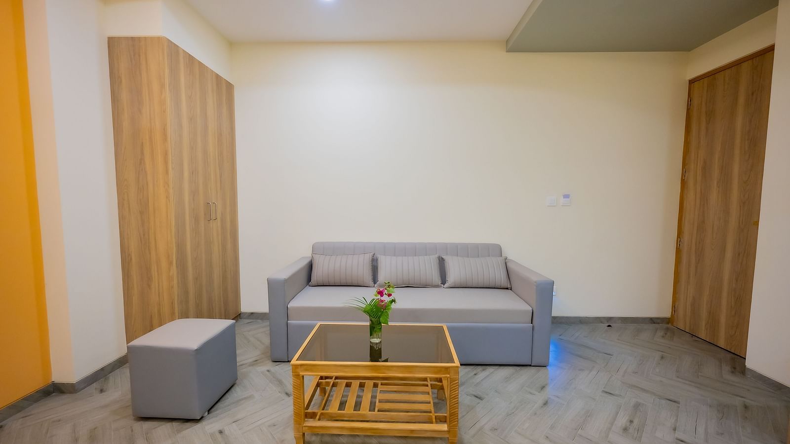 A seating area in a hotel room with a wooden table and sofas at Lotus Leaf Boutique Hotel.