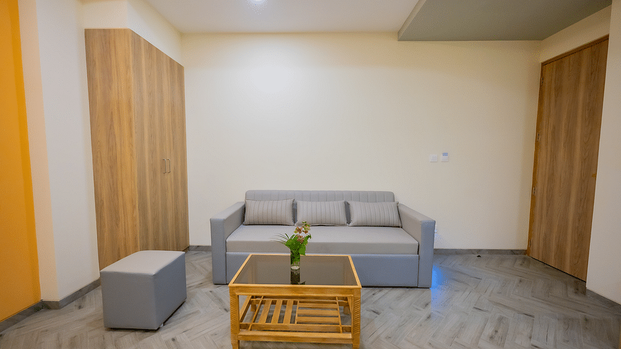 A seating area in a hotel room with a wooden table and sofas at Lotus Leaf Boutique Hotel.