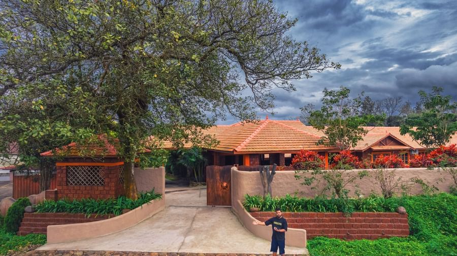 The main entrance of The Copper Edge - Eco Resort, Coorg, with a paved driveway leading to the building's facade.