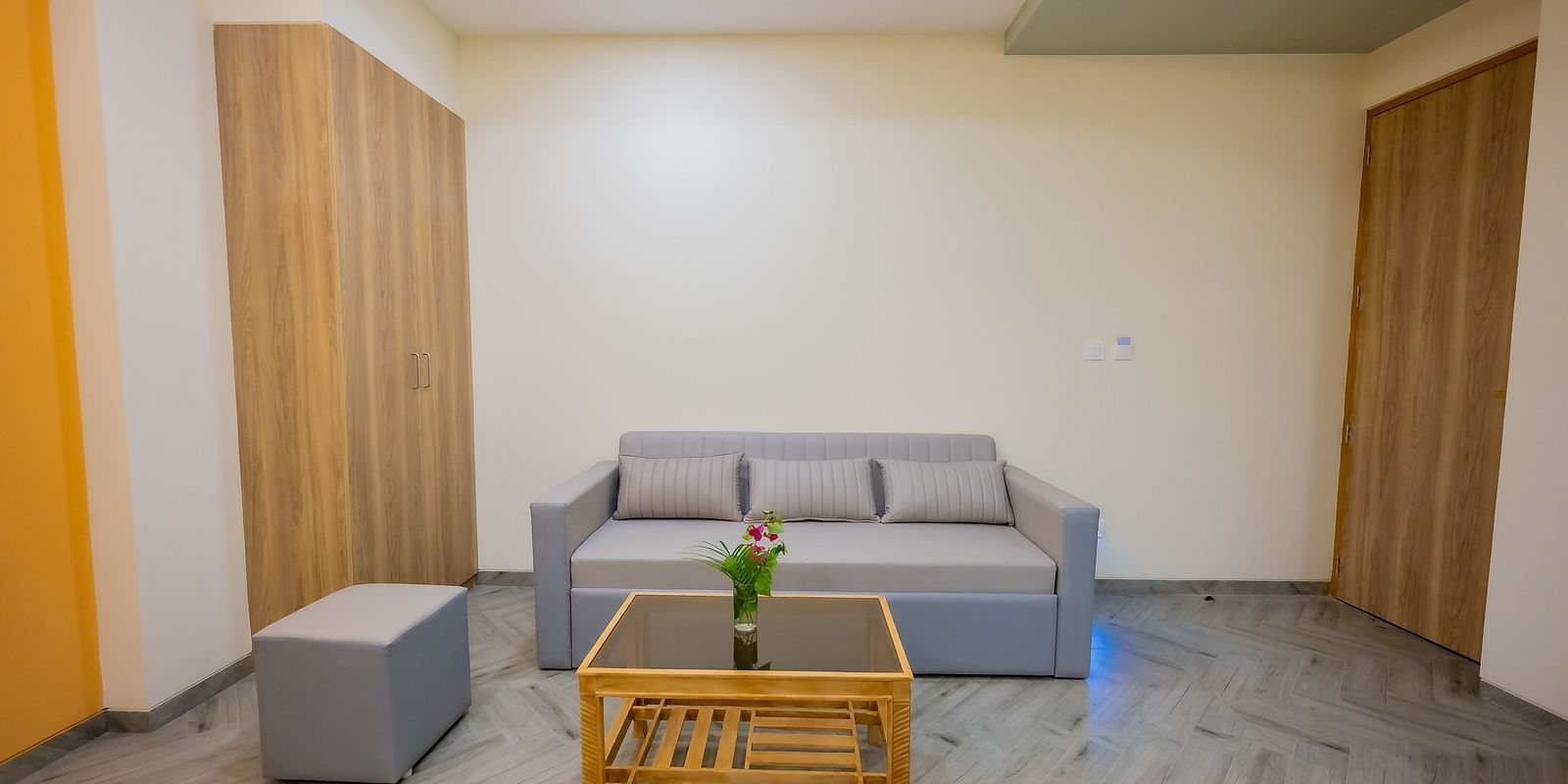 A seating area in a hotel room with a wooden table and sofas at Lotus Leaf Boutique Hotel.