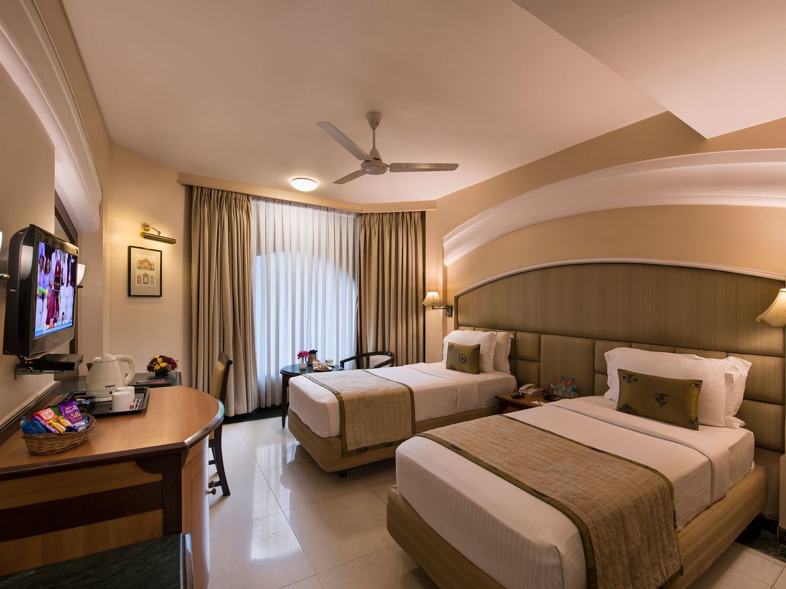 Hotel room with a seating area, a plush armchair, a lamp, and a decorative mirror - Lords Inn Vadodara