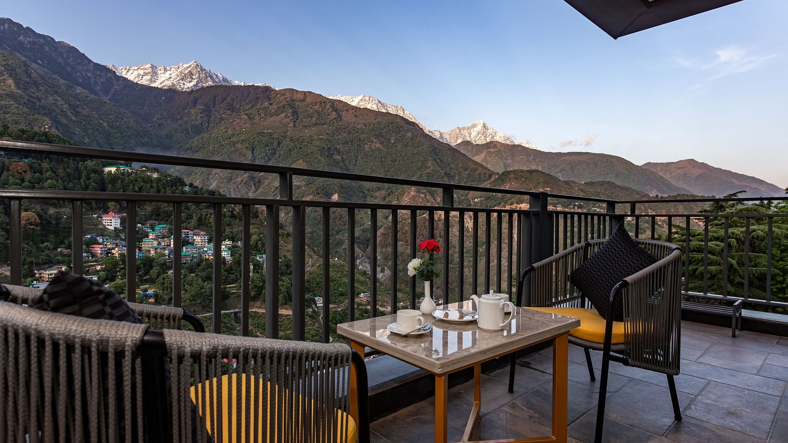 An image of the outdoor dining area with seating arrangement and scenic mountain views as the backdrop - The Belvedere Himalayan Retreat, McLeodganj