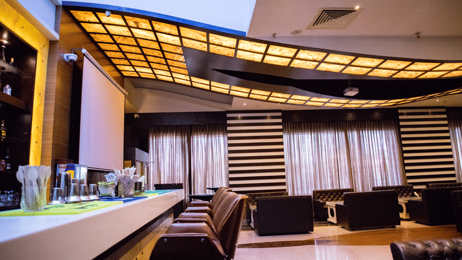 Side view shot of a bar counter with several elevated chairs lined on the bar counter at the Benzz Park, Vellore.