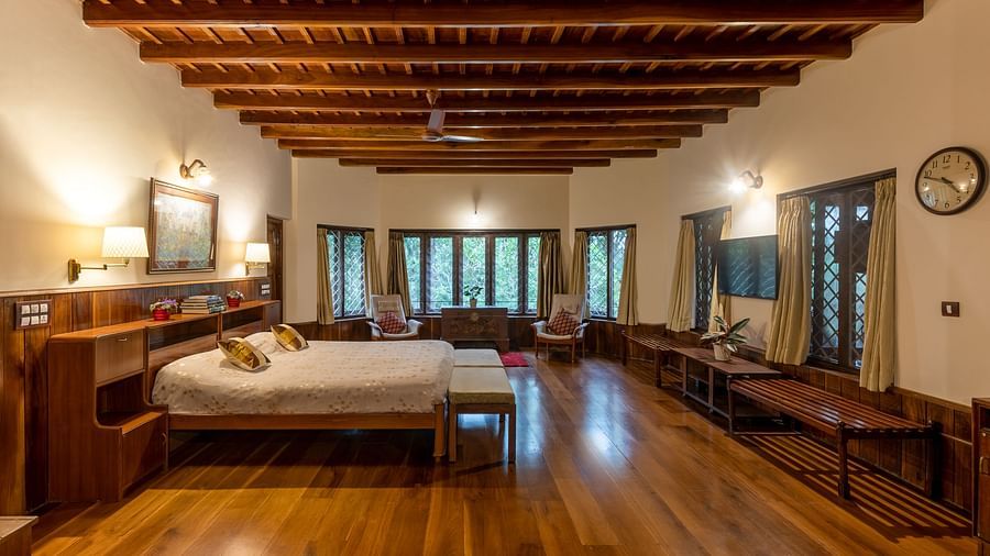 Spacious room with twin beds, wooden floors, and a distinctive wooden ceiling - BluSalzz Collection - Tranquil Resort, Wayanad