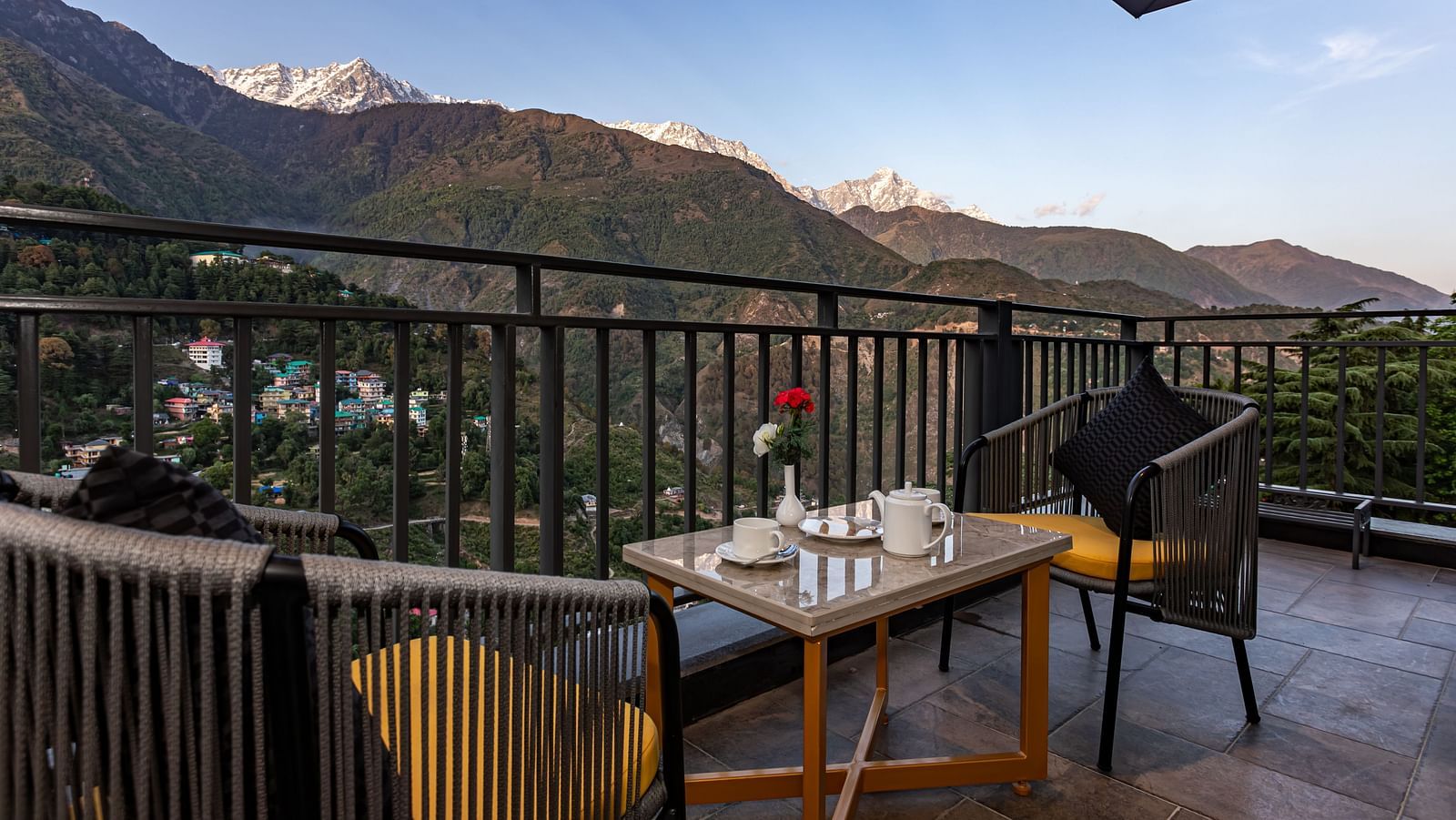 An image of the outdoor dining area with seating arrangement and scenic mountain views as the backdrop - The Belvedere Himalayan Retreat, McLeodganj