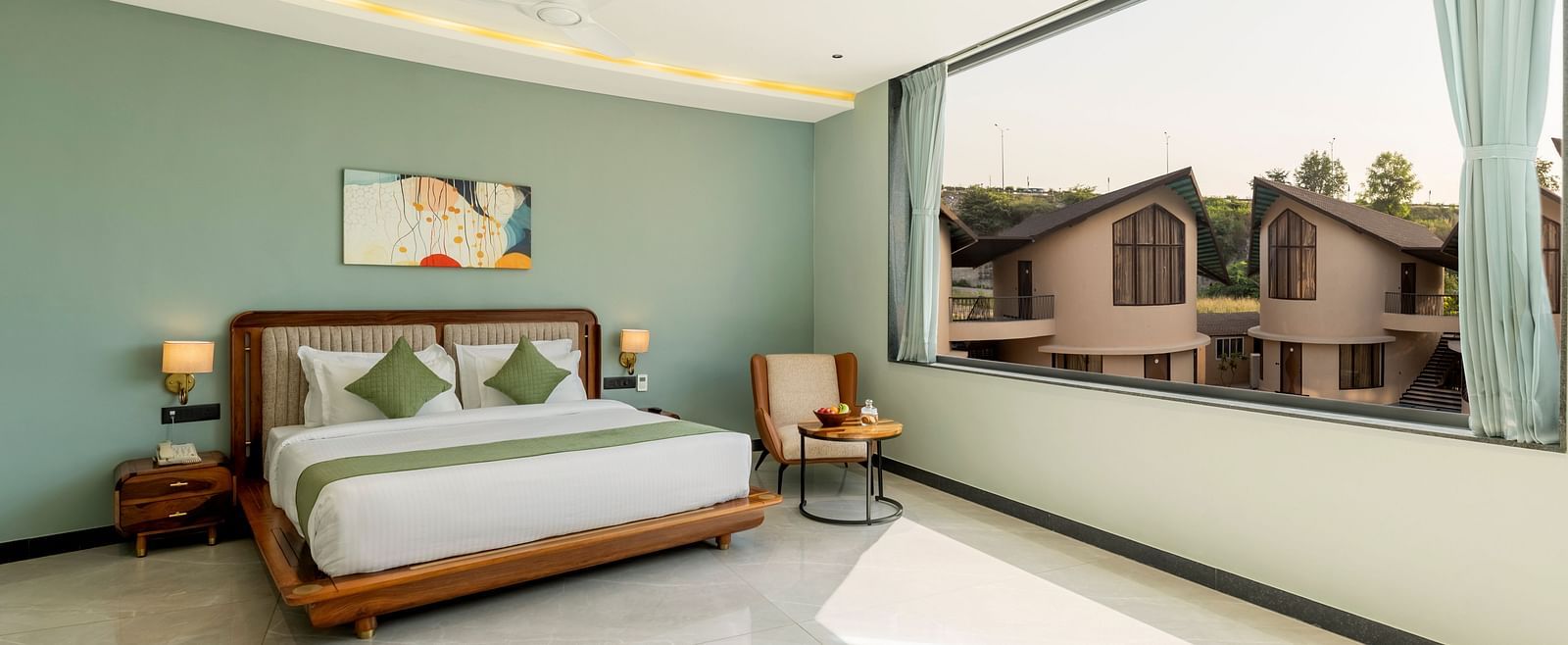 Pool View Room featuring a king size bed with a decorative headboard and a view from the window at The Qualia Resort Club & Brewery, Udaipur.