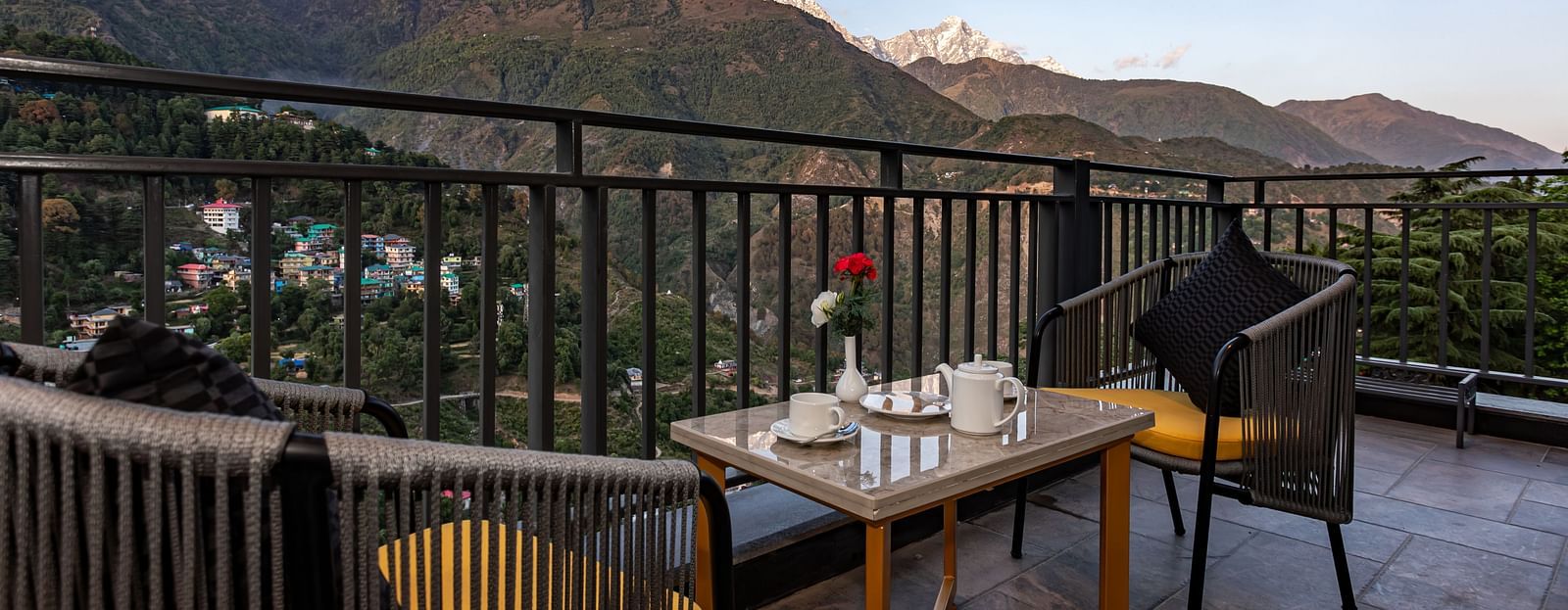 An image of the outdoor dining area with seating arrangement and scenic mountain views as the backdrop - The Belvedere Himalayan Retreat, McLeodganj