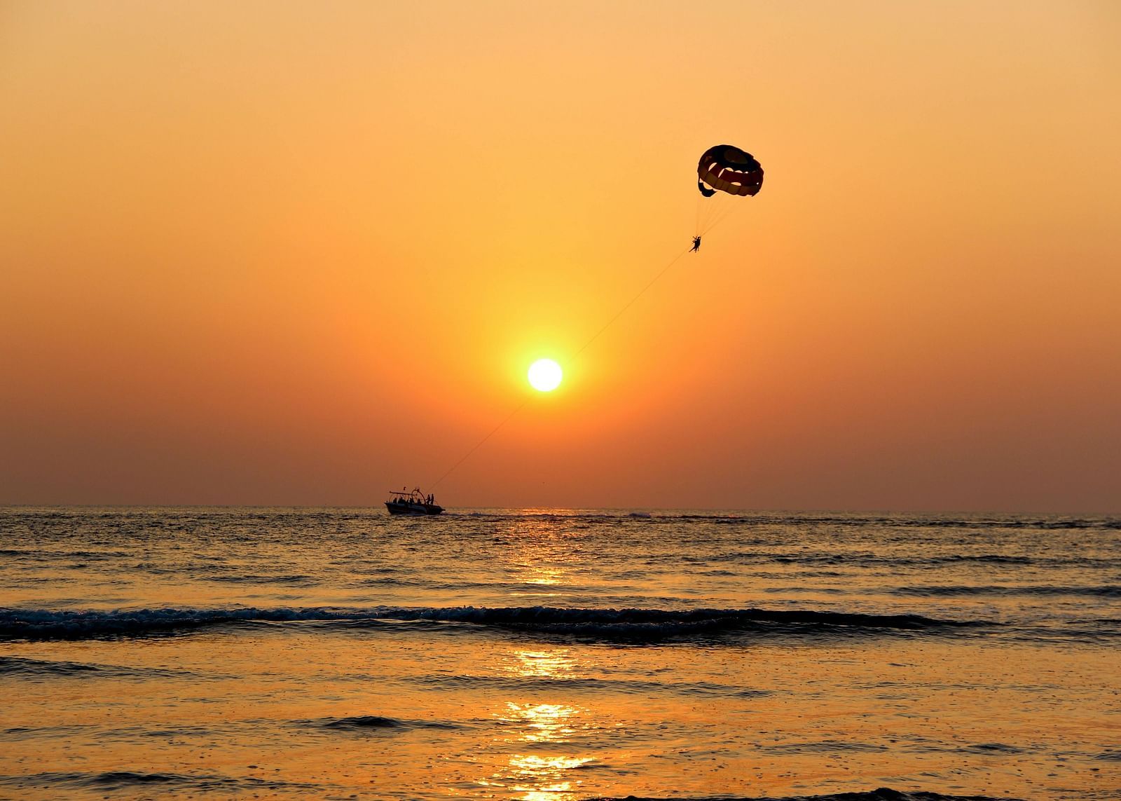 A person parasailing during sunset