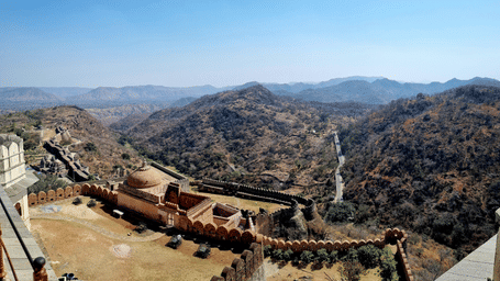 A road with vehicle visible from Kumbhalgarh Fort under a clear sky