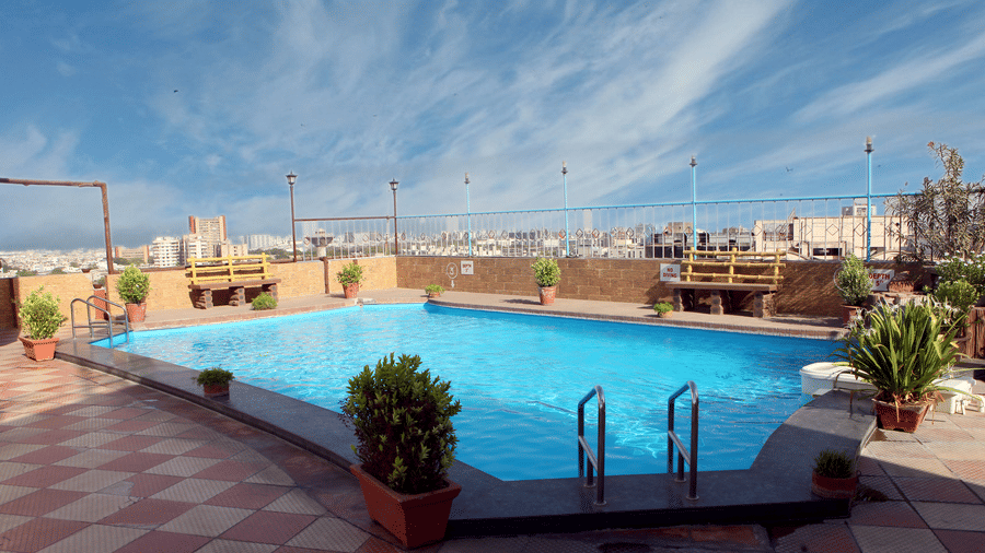 A rooftop swimming pool at Lords Plaza Surat offering a view of the city