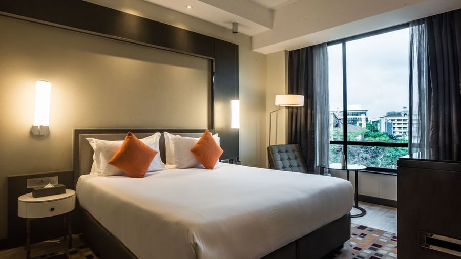 Deluxe room with large windows, orange accent pillows, and work desk at Best Western Premier Westlands hotel.