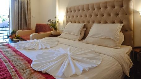 A neatly arranged bedroom with towel art on the bed and soft ambient lighting – The Verda de Miranda Resort.