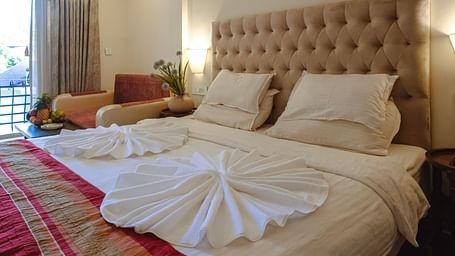 A neatly arranged bedroom with towel art on the bed and soft ambient lighting – The Verda de Miranda Resort.