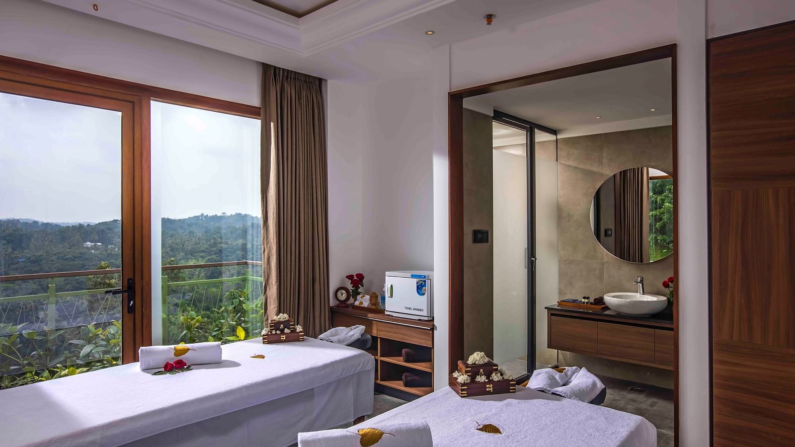 Image of two beds in the spa of the hotel wit a towel placed on the bed Drone shot of the hotel | Great Trails Wayanad by  GRT hotels.