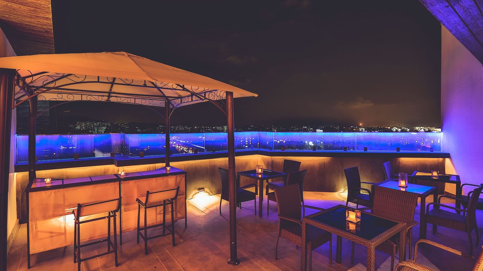 Rooftop seating with neon blue lights overlooking the city skyline at T24 Residency, Andheri East, Mumbai