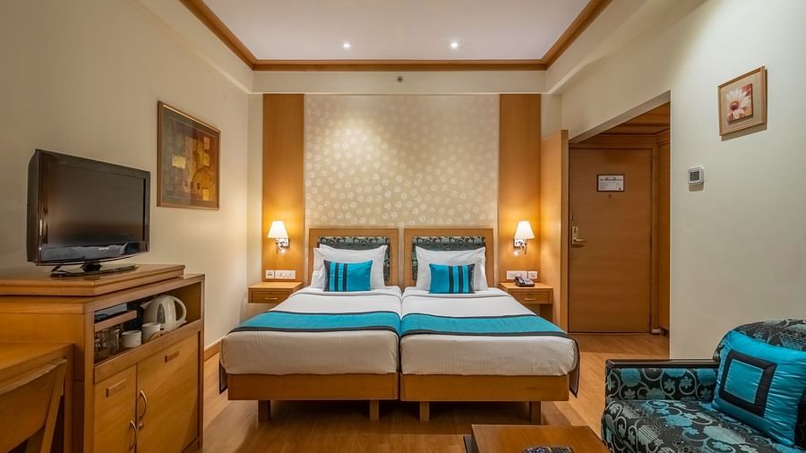 front view of twin beds with white and blue linen in the Executive Room - Kenilworth Hotel, Kolkata