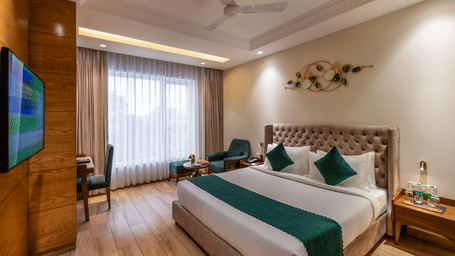 Lords hotel deluxe room with double bed, wooden furnishings, TV and window view.