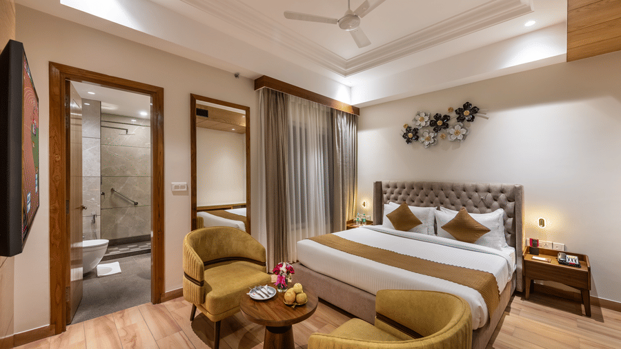 Standard room with double bed, round chairs, and neutral-toned modern interior.