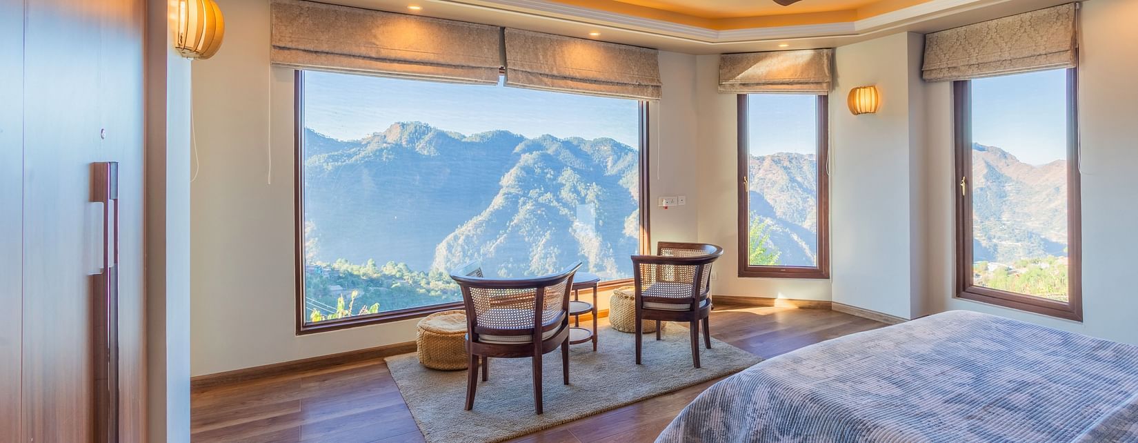 The Manor Shimla - The interiors of a room with a sitting area overlooking the mountains
