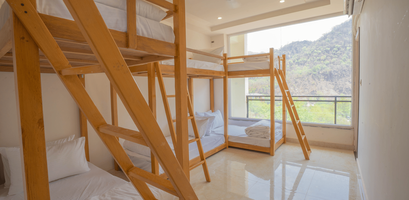 A modern, airy bunk bed room at Perfectstayz Value Alpine Retreat, Rishikesh with wooden frames and a scenic mountain view from the window.