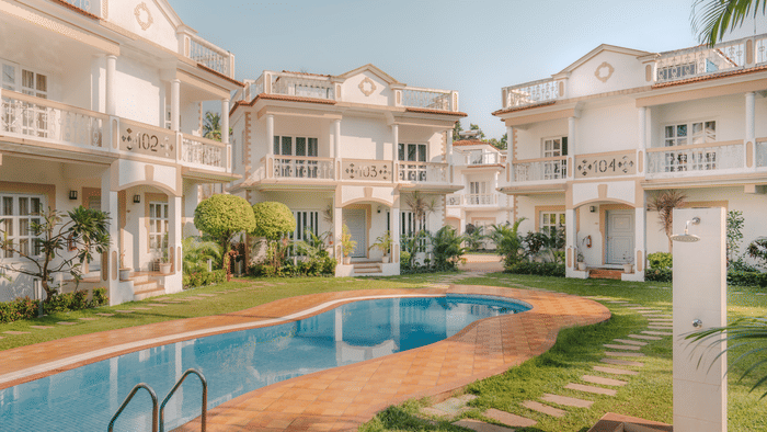 a bird's eye view of the hotel premises shows the pool surrounded by the hotel and palm trees - Richmonde Ananta Elite, Goa