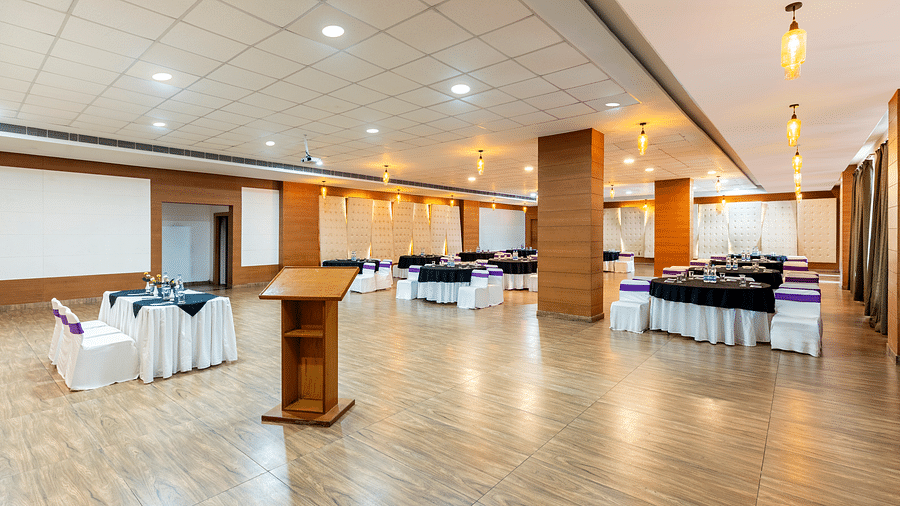 A event hall arranged with a podium, tables, chairs, and a polished floor - Via Lakhela Resort & Spa