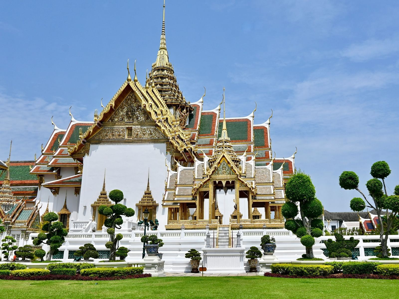 Overview of the grand palace in Bangkok with a garden in front of it.