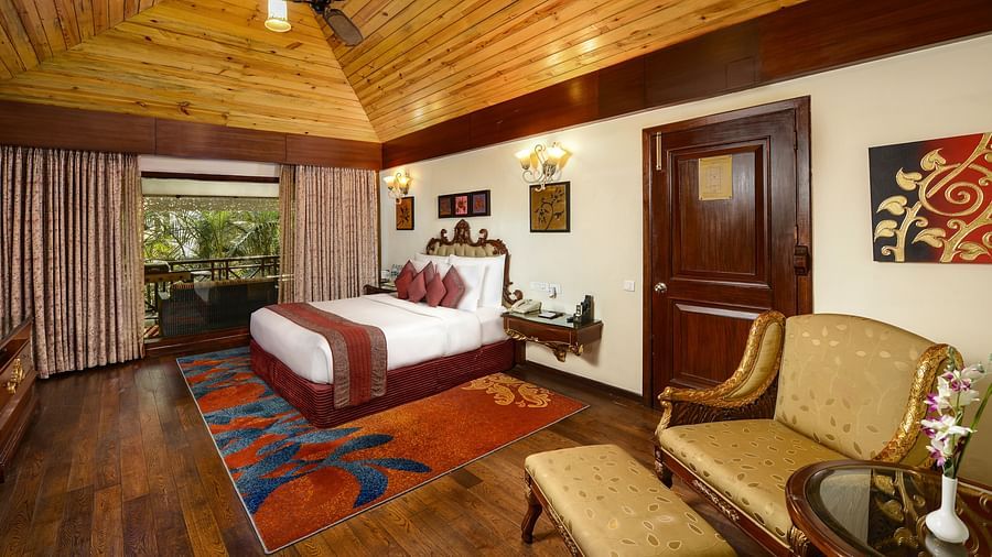 a king size bed and a seating space by it - Mayfair Spa Resort & Casino Gangtok 1