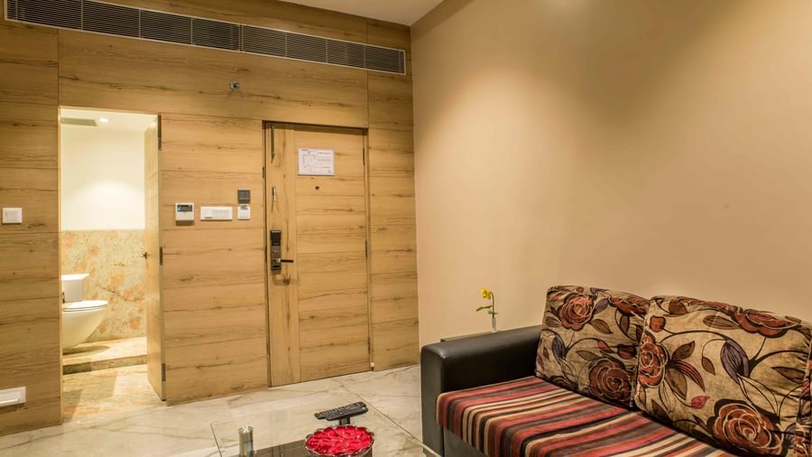 Hotel suite featuring a seating area with a patterned sofa and a separate bedroom | The Citi Residenci Hotel Durgapur