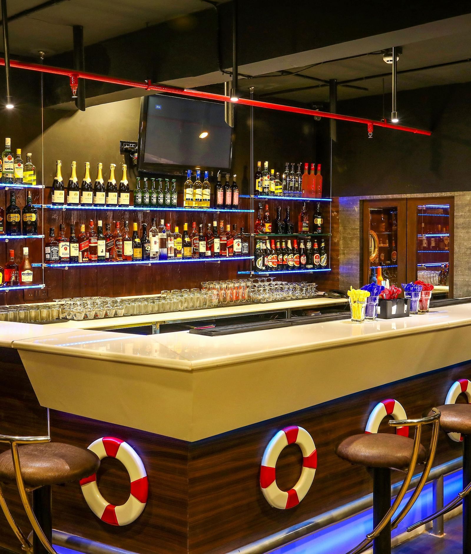 Image of On The Rocks bar counter and a shelf behind it with liquor in it at Hotel Aadithya, Chennai