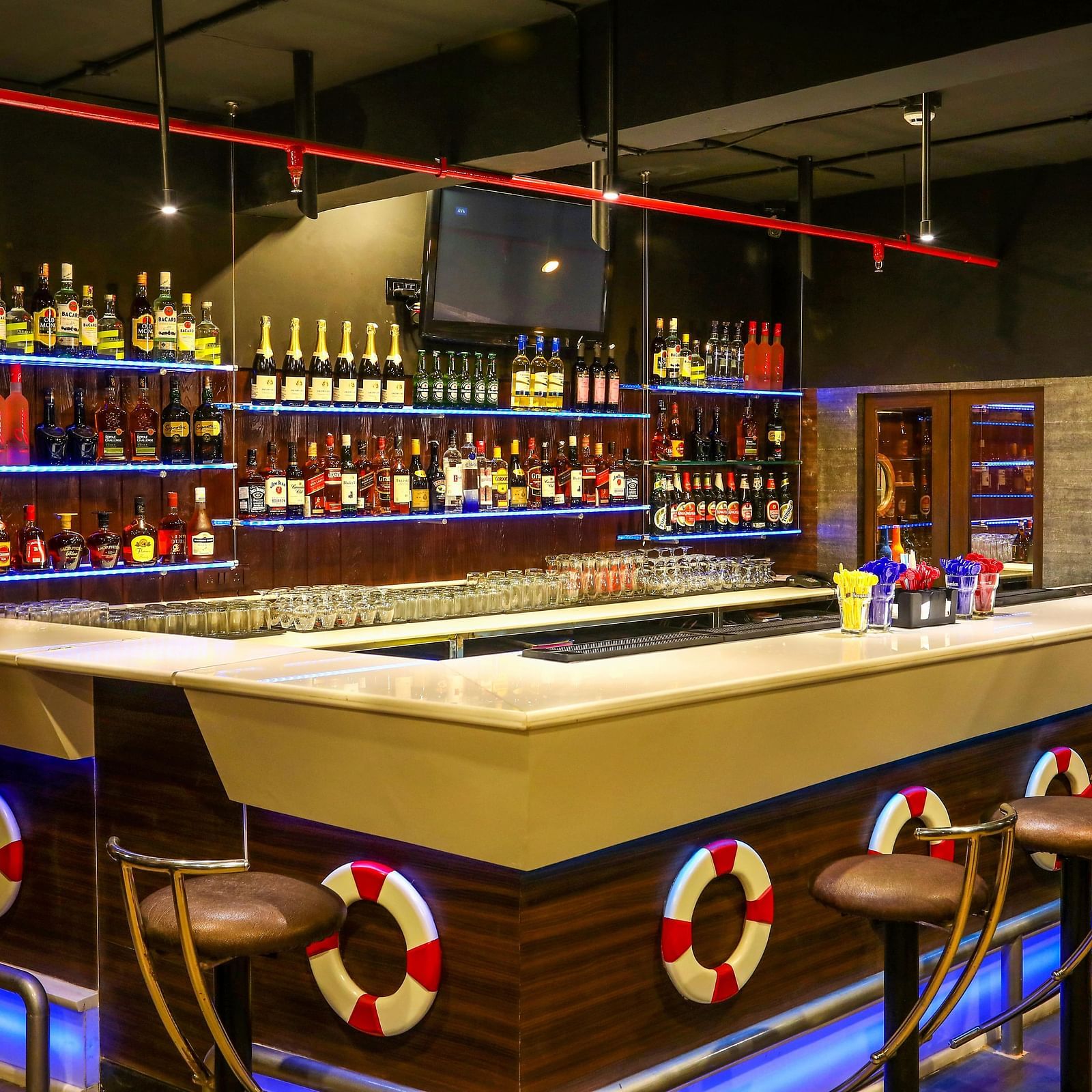 Image of On The Rocks bar counter and a shelf behind it with liquor in it at Hotel Aadithya, Chennai