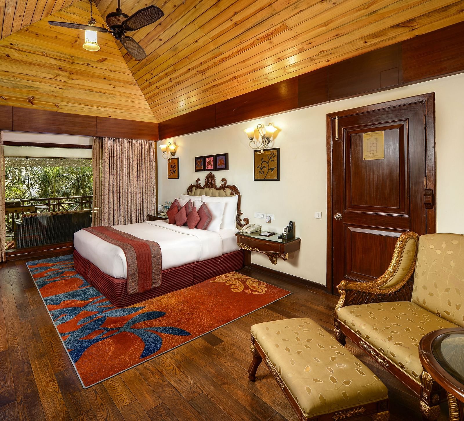 a king size bed and a seating space by it - Mayfair Spa Resort & Casino Gangtok 1