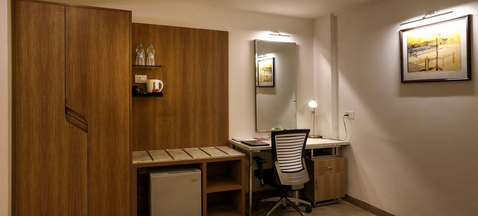 A room with a workdesk and a chair with paintings on the wall - Mango Hill Central, Chennai