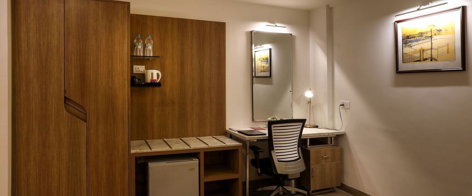 A room with a workdesk and a chair with paintings on the wall - Mango Hill Central, Chennai