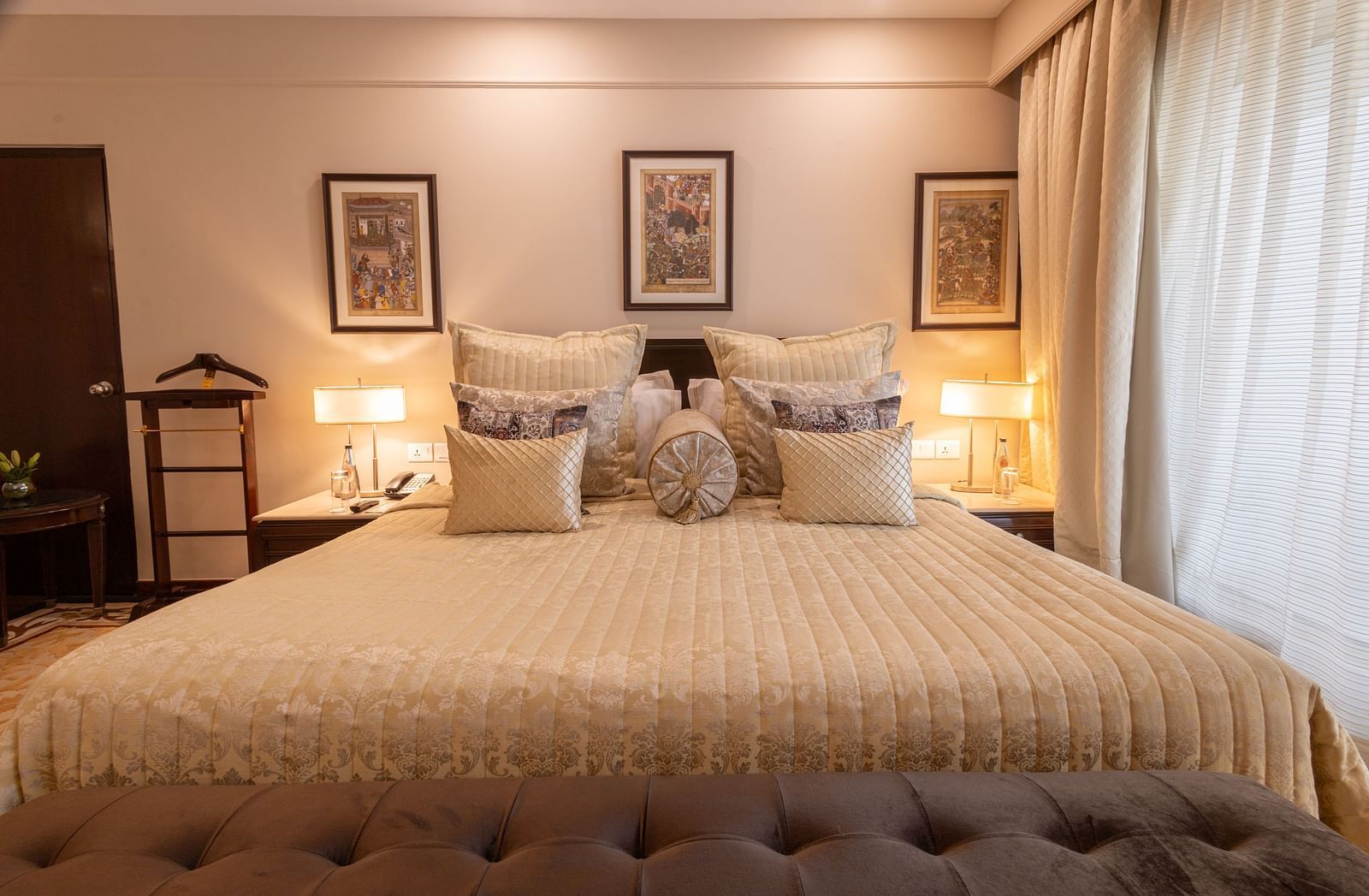 image of the king sized bed with three rectangular photo frames above the headboard of the bed at the heritage parlour room - The Claridges New Delhi