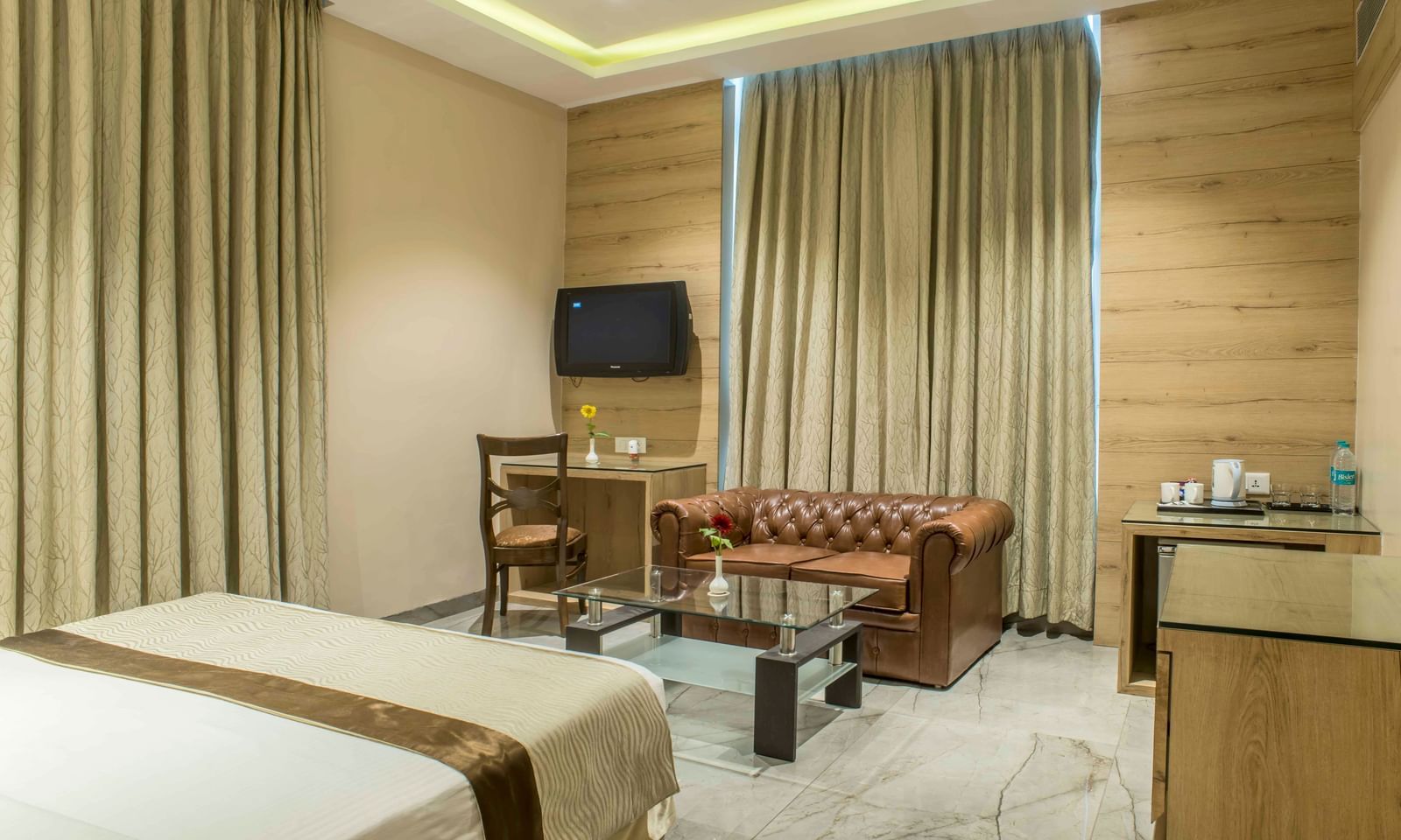 Well-furnished hotel room with a bed and a seating area | The Citi Residenci Hotel Durgapur