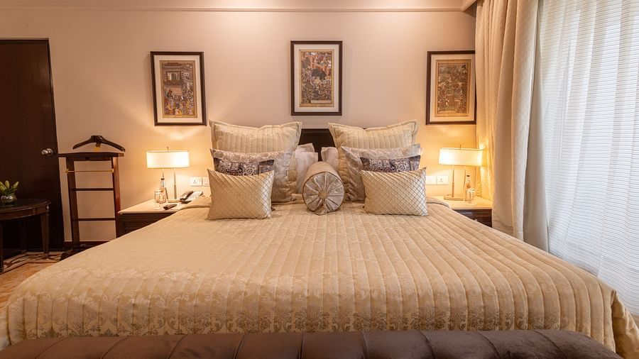 image of the king sized bed with three rectangular photo frames above the headboard of the bed at the heritage parlour room - The Claridges New Delhi