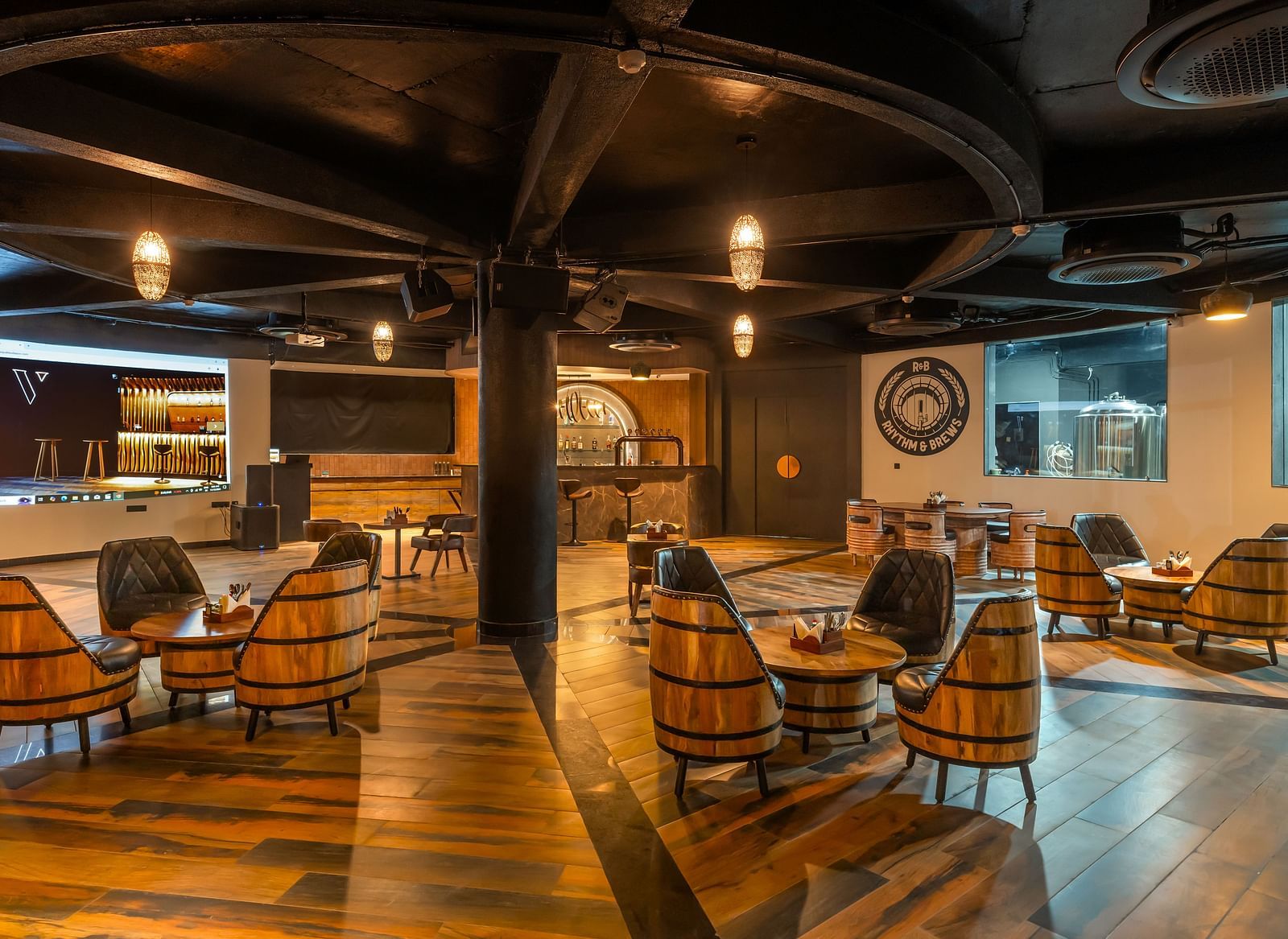 Rhythm & Brews furnished with wooden chairs and tables, creating a warm and inviting ambience at The Qualia Resort Club & Brewery, Udaipur.
