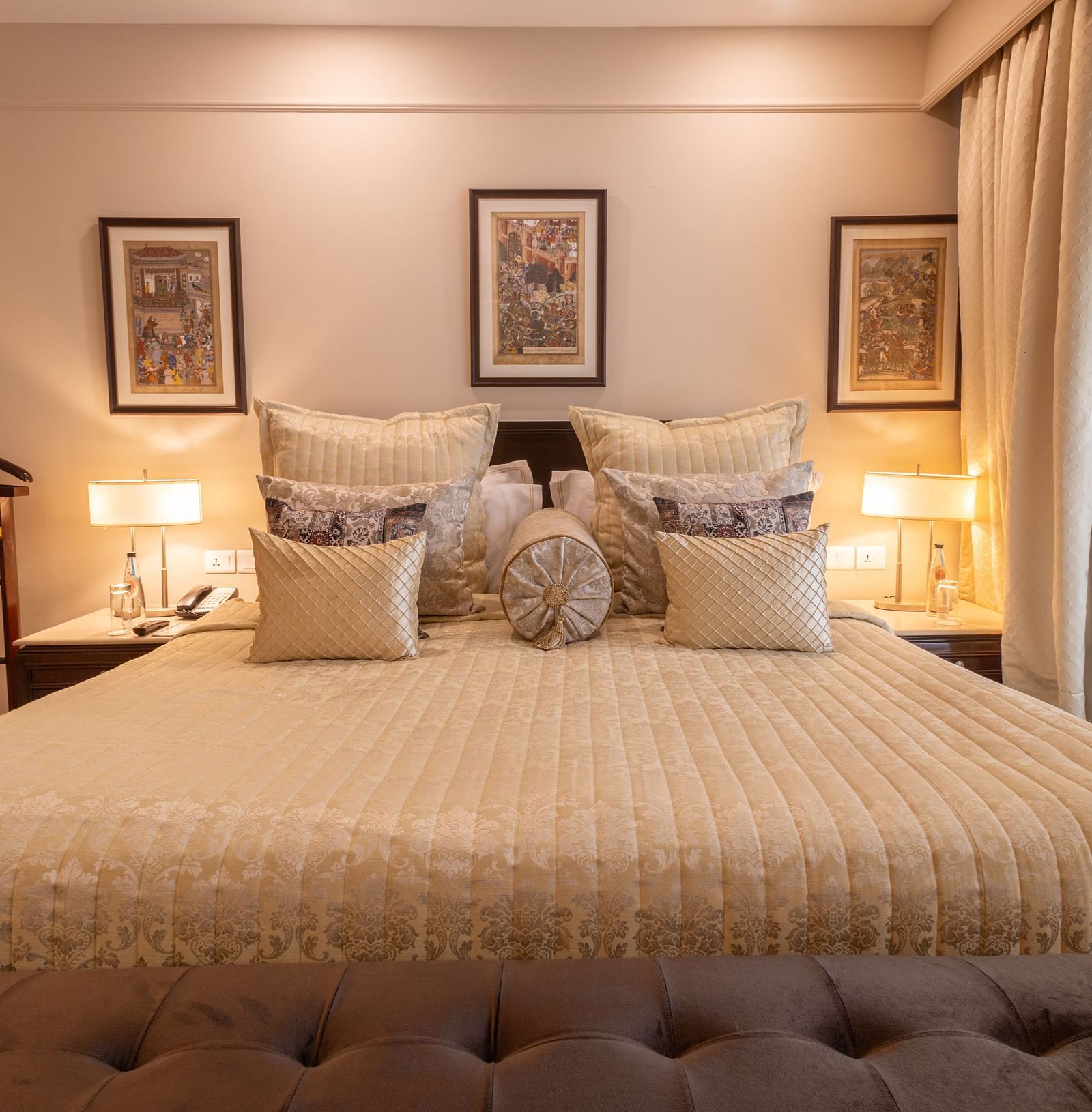 image of the king sized bed with three rectangular photo frames above the headboard of the bed at the heritage parlour room - The Claridges New Delhi