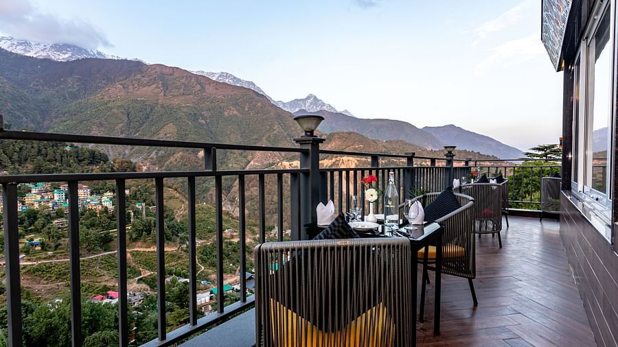 An image of the outdoor dining area with seating arrangement and scenic mountain views as the backdrop - The Belvedere Himalayan Retreat, McLeodganj