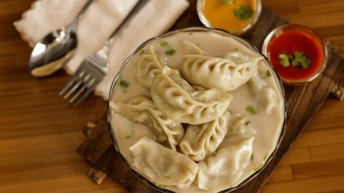 Hot steaming Momos served with red and yellow chutney