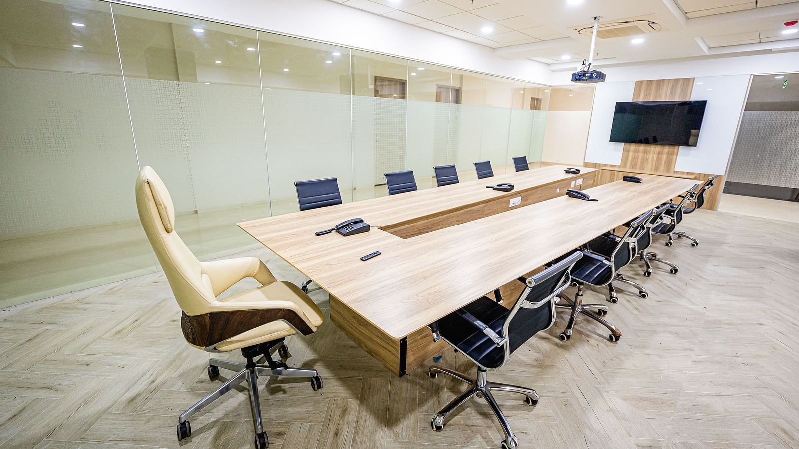 A modern conference room with glass walls, a large table, and chairs at Lotus Leaf Boutique Hotel.