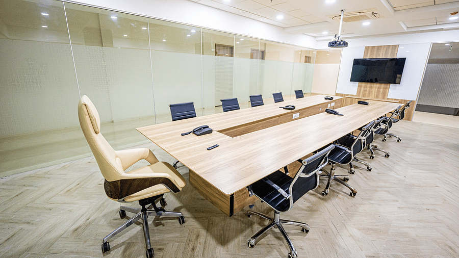A modern conference room with glass walls, a large table, and chairs at Lotus Leaf Boutique Hotel.