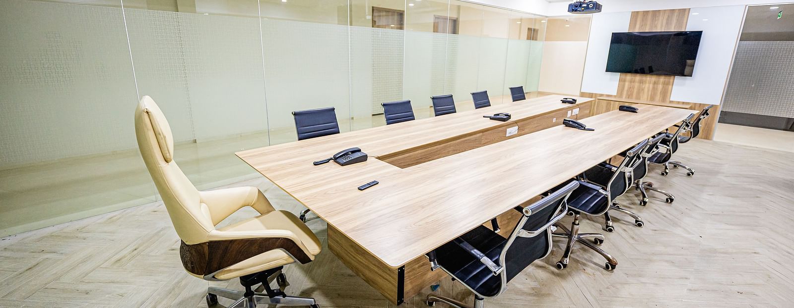 A modern conference room with glass walls, a large table, and chairs at Lotus Leaf Boutique Hotel.