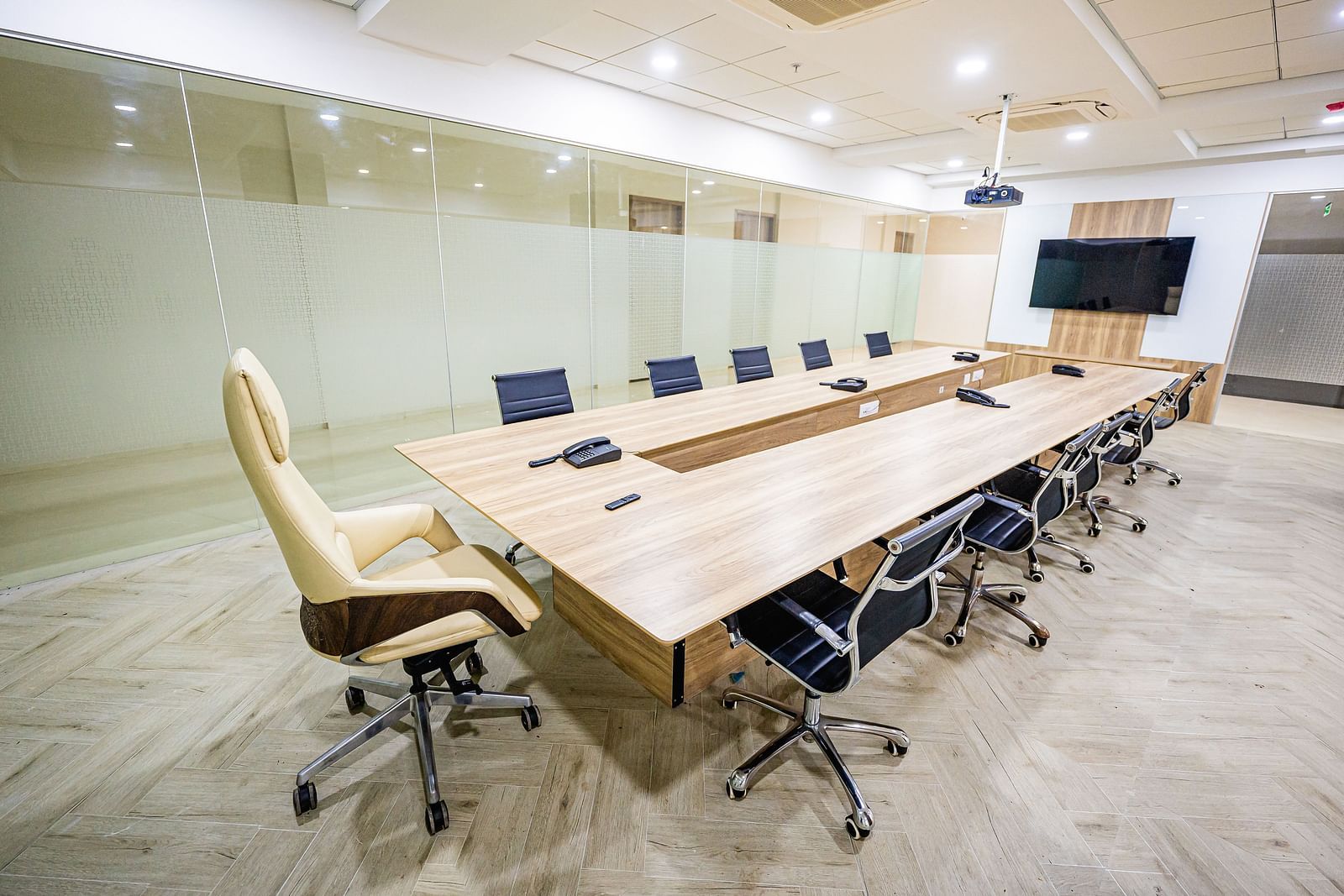 A modern conference room with glass walls, a large table, and chairs at Lotus Leaf Boutique Hotel.