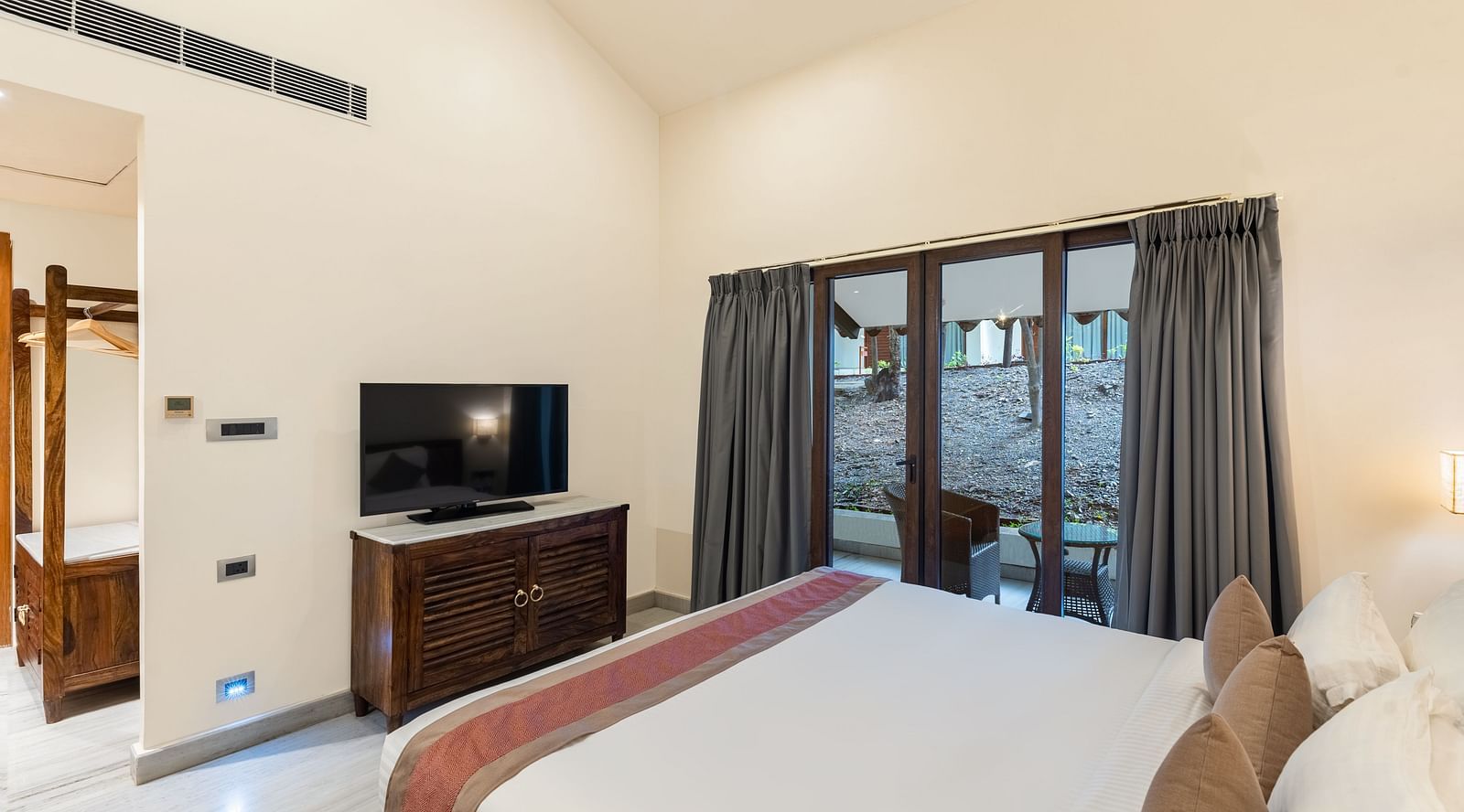 image of a bedroom featuring a comfortable king size be d with the television placed opposit to it at the luxury family suite in aranya vilas in udaipur