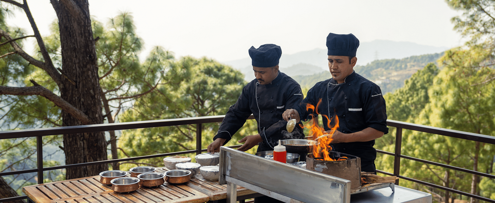 Two chefs cooking on a terrace at BluSalzz Escapade Resort, Lansdowne