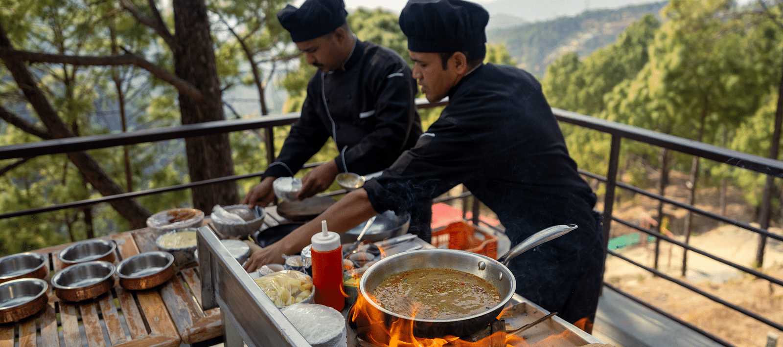 Two persons grilling food on a terrace at BluSalzz Escapade Resort, Lansdowne