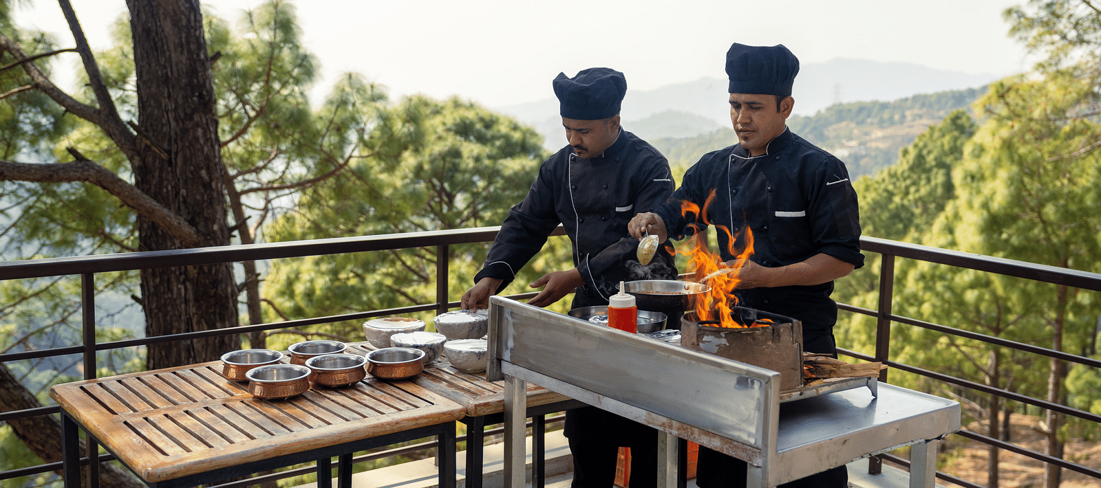 Two chefs cooking on a terrace at BluSalzz Escapade Resort, Lansdowne